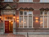 a brick building with a red door and windows at Hotel Mercier in Amsterdam