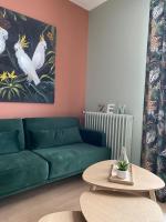 a living room with a green couch and a table at Villa st Louis 2 in Cabourg