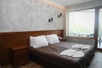 A bed or beds in a room at Petrov Family Hotel