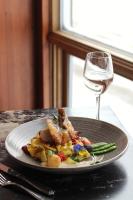 a plate of food on a table with a glass of wine at Gîte du Mont-Albert - Sepaq in Sainte-Anne-des-Monts