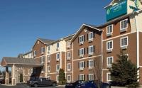Un gran edificio de ladrillos con coches aparcados en un estacionamiento. en WoodSpring Suites Allentown Bethlehem, en Bethlehem