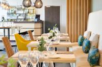 アングレットにあるレ テラス ダトゥランタルの木製のテーブル、グラス、椅子のあるレストラン