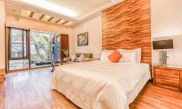 a bedroom with a large bed and a television at Yage Hotspring House in Jiaoxi