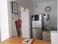 eine Küche mit einem Kühlschrank und einem Tisch mit einem Buch in der Unterkunft Fréjus plage in Fréjus