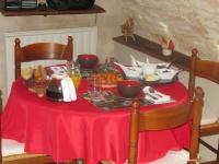 a table with a red table cloth and food on it at Murmure des buis in Corveissiat