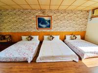 two beds in a room with a brick wall at Pulicity Villa B&amp;B in Puli