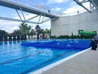 a pool of blue water in front of a building at Ruben Apartman City Center in Debrecen