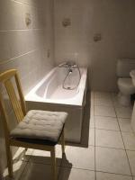 a bathroom with a tub and a chair and a toilet at Les Fleurs in Monpazier