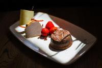 Un plato con un pastel de chocolate y fresas encima. en Hagen`s Hotel "eat & meet" Restaurant Bar Lounge, en Haren