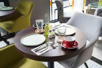 een houten tafel met borden en glazen erop bij Barito Mansion in Jakarta