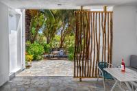 an open door to a patio with a table and chairs at Coralli Seaside Resort in Livadakia