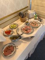 a white table with plates of food on it at Trollnäs Gårdshotell in Svärdsjö