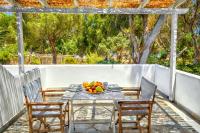 a table with a bowl of fruit on a patio at Coralli Seaside Resort in Livadakia