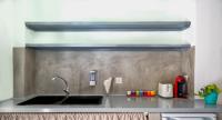 a kitchen with a sink and a counter top at Coralli Seaside Resort in Livadakia