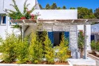 a white house with flowers on the facade at Coralli Seaside Resort in Livadakia