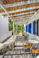 a patio with tables and chairs under a pergola at Coralli Seaside Resort in Livadakia