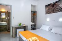 a bedroom with a bed and a desk in a room at Coralli Seaside Resort in Livadakia