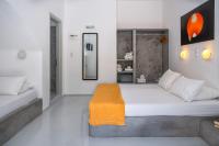 a bedroom with a large bed with an orange blanket on it at Coralli Seaside Resort in Livadakia