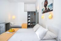 a bedroom with a bed with a bowl of fruit on it at Coralli Seaside Resort in Livadakia