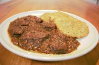 a plate of food with meat and bread on a table at Masarykova chata na Beskydě in Bumbalka