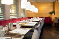 a dining room with a long table and red chairs at Holiday Inn Vienna City by IHG in Vienna