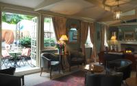 a living room with chairs and tables and a fireplace at The Rookery in London