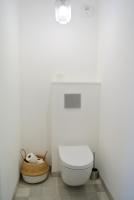 a white bathroom with a toilet and a basket at Arbre Blanc, une folie montpelliéraine in Montpellier