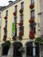 un edificio amarillo con flores en las ventanas en Hotel Cheval De Bronze, en Remiremont