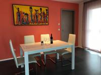 a dining room with a white table and white chairs at Panorama Apartman in Velence