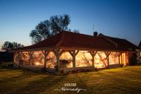 a large building with a roof on a field at Siedlisko Nawiady - hotel butikowy in Nawiady