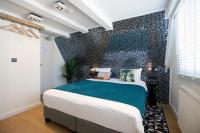 a bedroom with a large bed with a black tiled wall at Quentin Golden Bear Hotel in Amsterdam