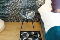 a cat sleeping in a basket next to a bed at Quentin Golden Bear Hotel in Amsterdam