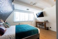 a bedroom with a bed and a window and a desk at Quentin Golden Bear Hotel in Amsterdam