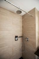 a shower in a bathroom with wooden walls at Quentin Golden Bear Hotel in Amsterdam