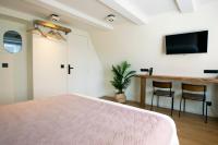 a bedroom with a bed and a desk and a tv at Quentin Golden Bear Hotel in Amsterdam