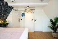 a bedroom with white cabinets and a bed and a plant at Quentin Golden Bear Hotel in Amsterdam