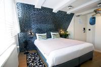 a bedroom with a bed with a blue wall at Quentin Golden Bear Hotel in Amsterdam