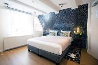 a bedroom with a bed and a wall with blue tiles at Quentin Golden Bear Hotel in Amsterdam