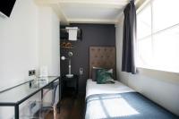 a small bedroom with a bed and a desk at Quentin Golden Bear Hotel in Amsterdam