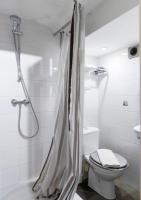 a bathroom with a shower curtain and a toilet at Quentin Golden Bear Hotel in Amsterdam