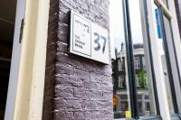 a sign on the side of a brick building at Quentin Golden Bear Hotel in Amsterdam