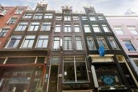 a tall building with many windows on a city street at Quentin Golden Bear Hotel in Amsterdam