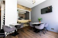 a room with two tables and chairs and a television at Quentin Golden Bear Hotel in Amsterdam