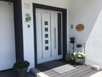 a front door of a house with two potted plants at Almwirt in Bramberg am Wildkogel