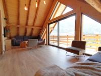 un grand salon avec une grande fenêtre dans l&#39;établissement Chalet Le Petit Plus, à Vaujany