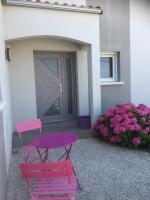 a pink table and a pink chair in front of a house at Chambre les Hortensias in Challans