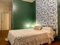 a bedroom with a bed and a green wall at La Maisonnette in Vichy