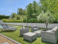 a patio with chairs and a table and a tree at Cosy villa with private pool in Emponse