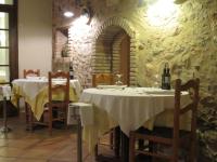 a dining room with two tables and a stone wall at Hotel Santa Anna in L'Estartit