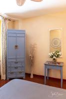 a bedroom with a blue cabinet and a table at Le Relais Des Dentelles in Beaumes-de-Venise